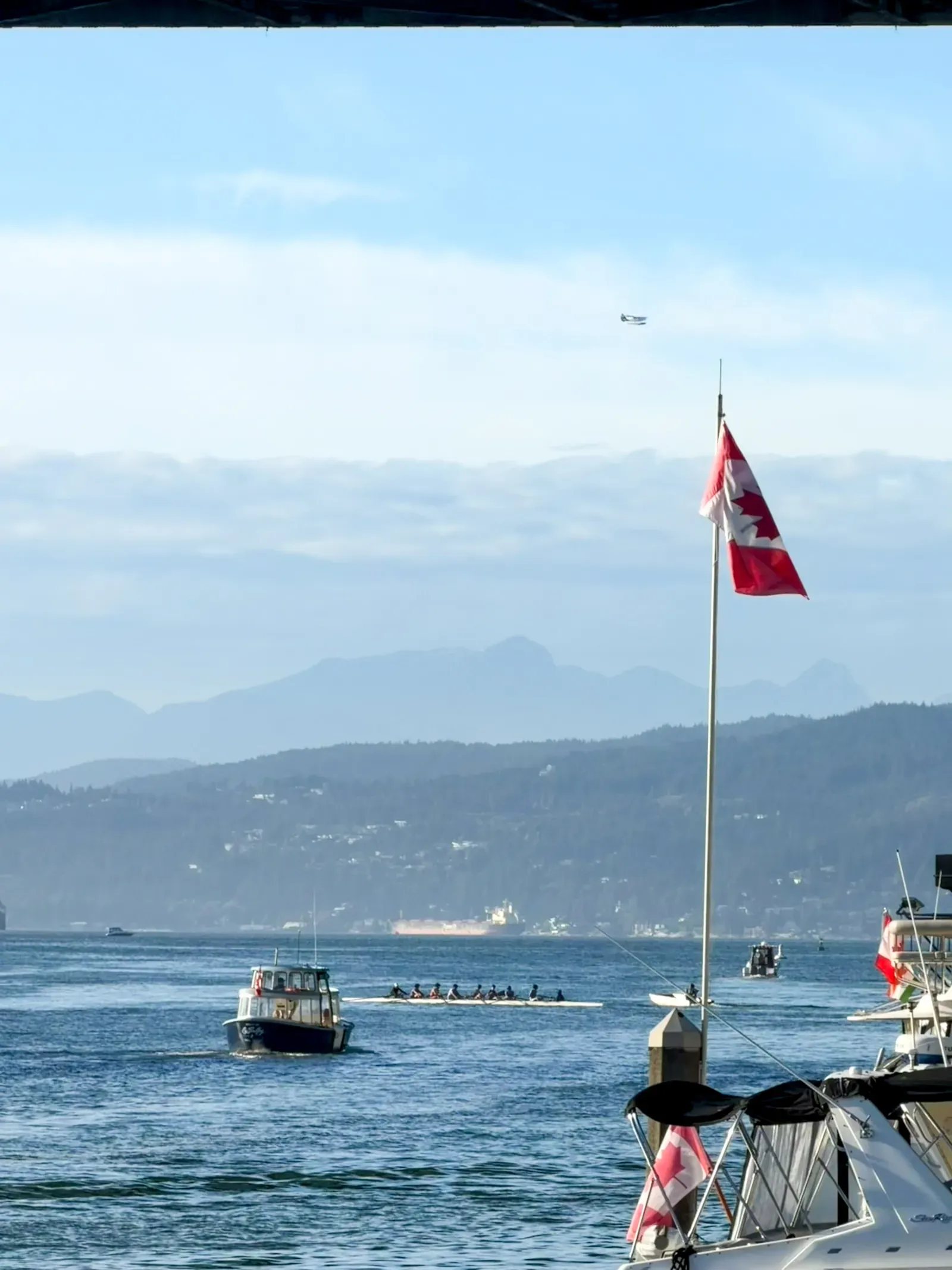 Vancouver harbour: a Canadian flag, small boats, mountains behind