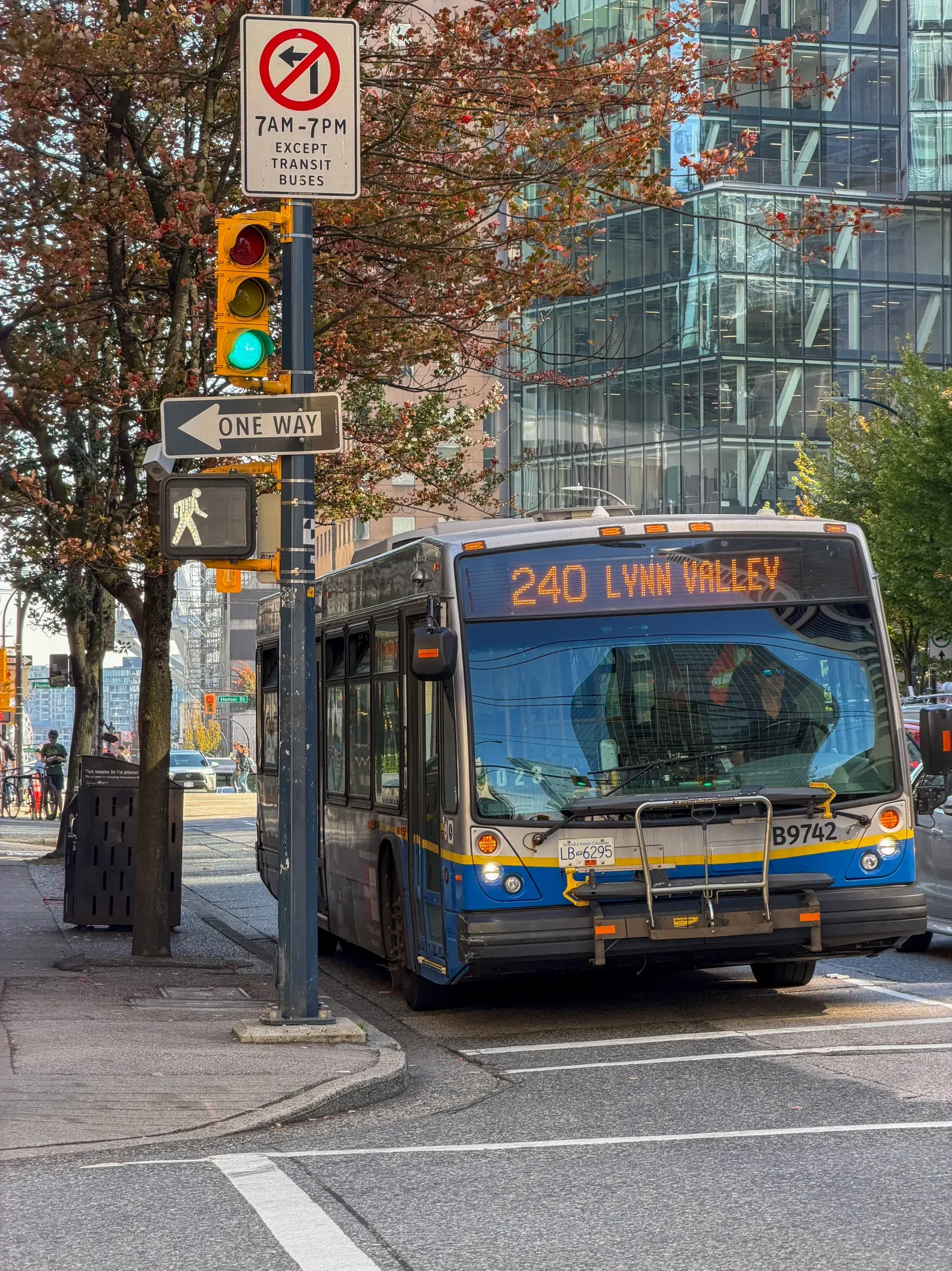 A city street in Vancouver, a transit bus, autumn trees